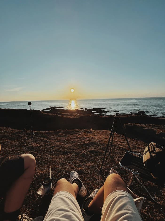 A quiet coastline at sunset with Brian relaxing outdoors.